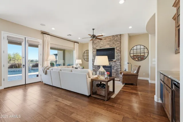 a living room with furniture kitchen area and a large window
