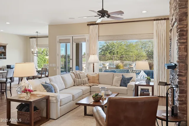 a kitchen with stainless steel appliances granite countertop a stove and a view of living room with a large window