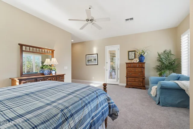 a spacious bathroom with a granite countertop double vanity sink a mirror a bathtub and window