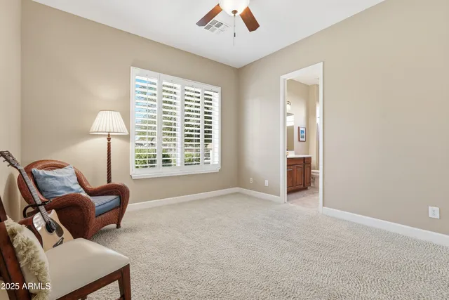 a living room with patio furniture and a floor to ceiling window