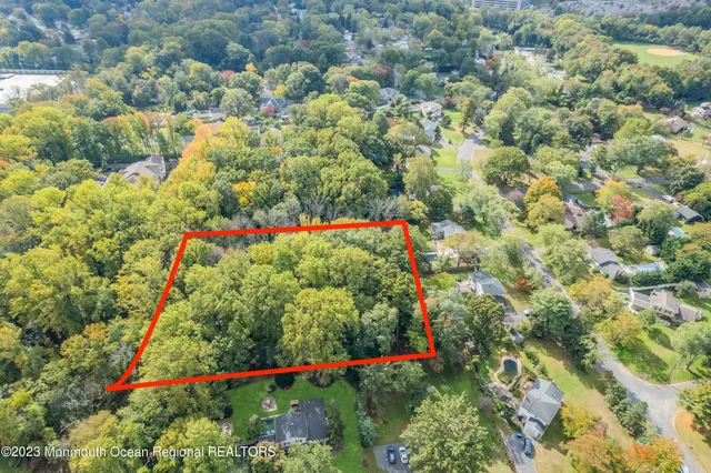 an aerial view of residential houses with outdoor space and trees