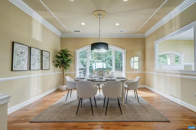 a dining room with furniture a chandelier and wooden floor