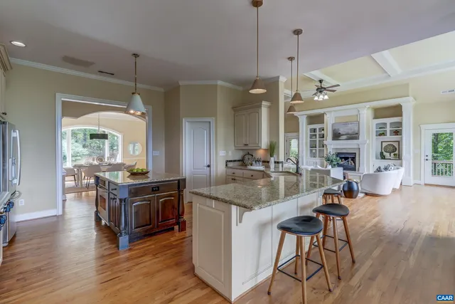 a spacious bedroom with a large bed a chandelier and windows