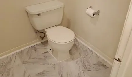 a white toilet sitting next to a shower