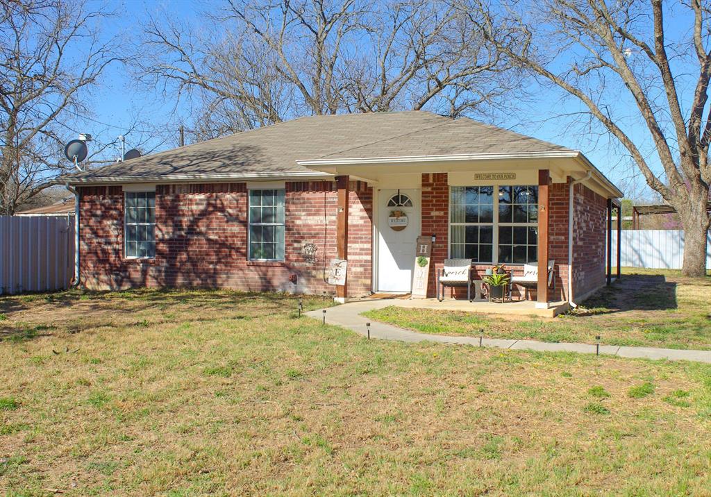 410 Joyce Street Rising Star, TX 76471 - Photo 1 of 1 Ranch-style house featuring brick siding, fence, and a front lawn