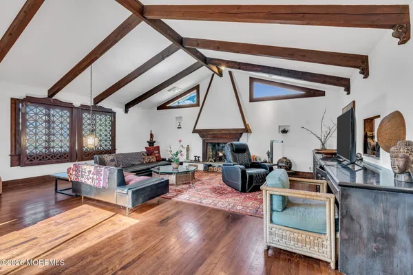 a living room with furniture a fireplace and wooden floor