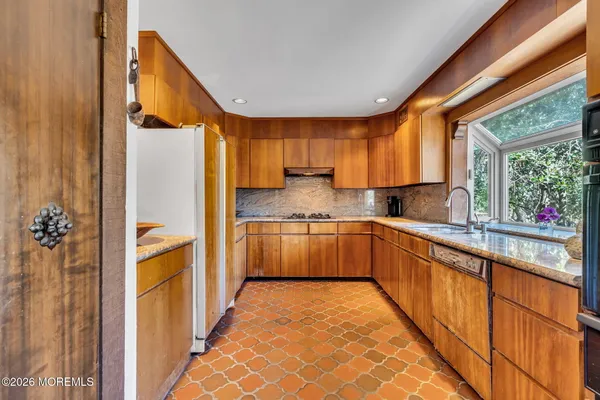 a kitchen with stainless steel appliances a refrigerator and a stove top oven