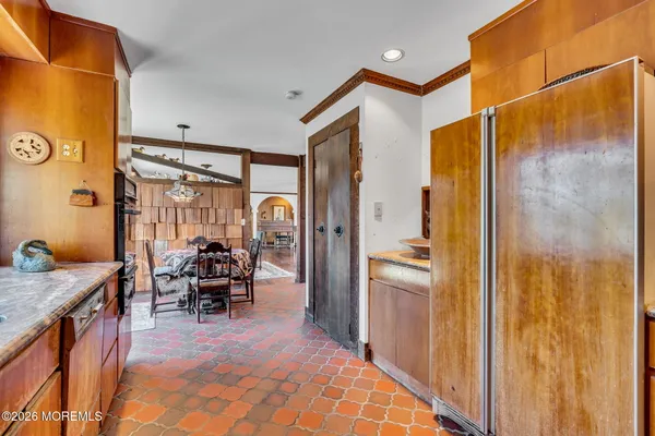 a dining room with stainless steel appliances granite countertop furniture and a gate
