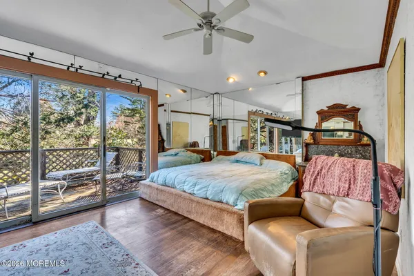 a bedroom with a bed couch and wooden floor