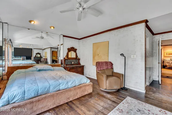 a bedroom with a bed and dresser with mirror