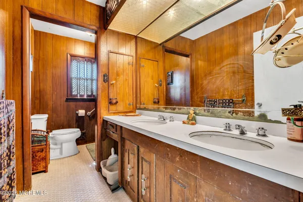 a bathroom with a double vanity sink toilet and a tub