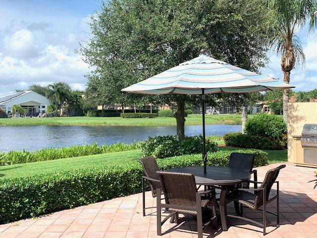 6967 Corning Circle Boynton Beach, FL 33437 - Photo 38 of 62 a view of a table and chairs under an umbrella