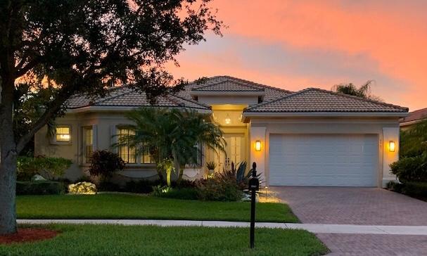 6967 Corning Circle Boynton Beach, FL 33437 - Photo 6 of 62 a front view of a house with a garden and yard