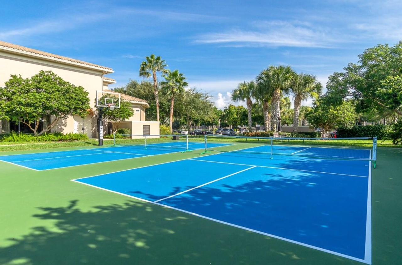 6967 Corning Circle Boynton Beach, FL 33437 - Photo 57 of 62 a view of a tennis ground with large trees