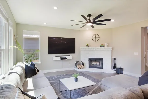 a living room with furniture a fireplace and a flat screen tv