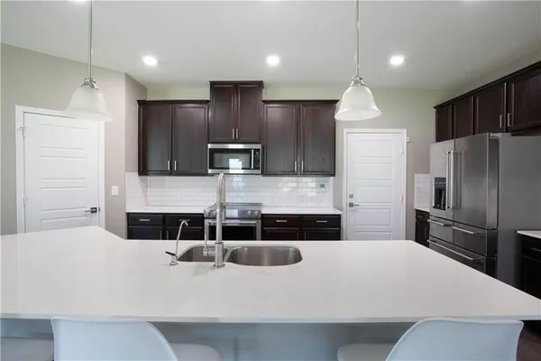 a kitchen with stainless steel appliances a refrigerator and a stove top oven