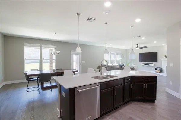 a kitchen with a sink and chairs