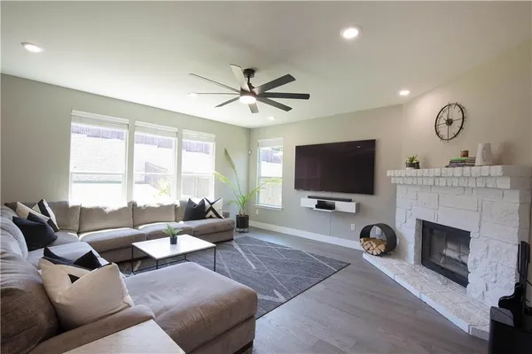 a living room with furniture a flat screen tv and a fireplace