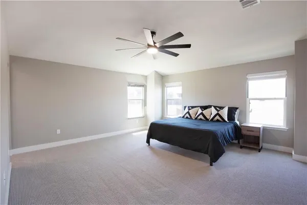 a spacious bedroom with a bed and a window