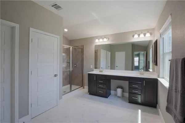 a spacious bathroom with a double vanity sink and a mirror