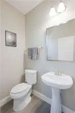 a bathroom with a toilet a sink and mirror