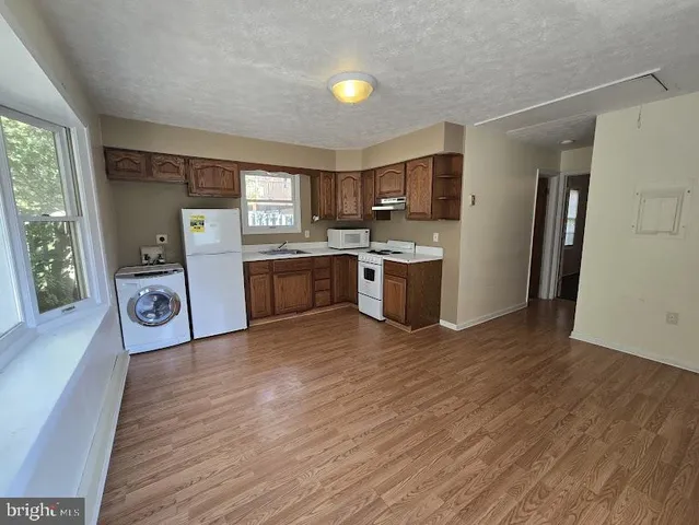 a view of a kitchen with a sink cabinets and wooden floor