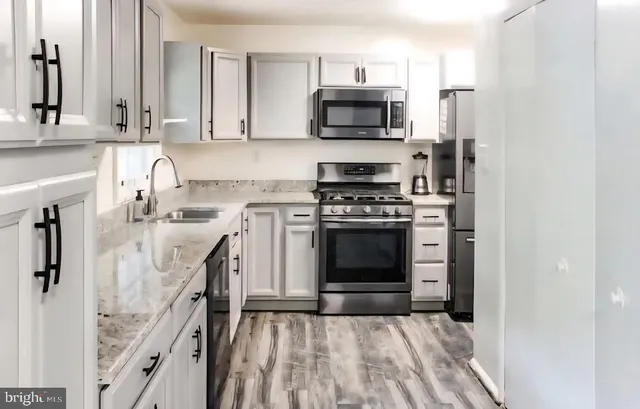 a kitchen with stainless steel appliances a stove a sink and a microwave