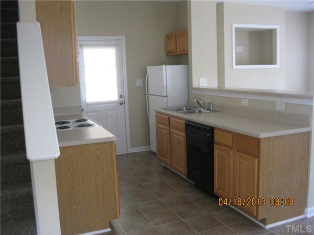 5908 Wynmore Road Raleigh, NC 27610 - Photo 4 of 7 a kitchen with a sink a refrigerator and cabinets