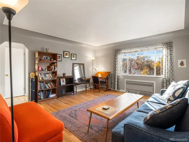 a living room with furniture a large window and bookshelf