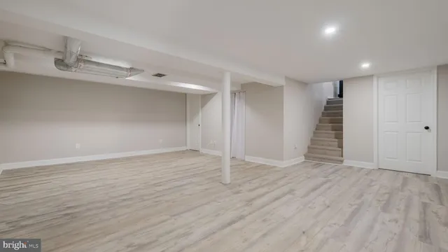 an empty room with wooden floor and white walls