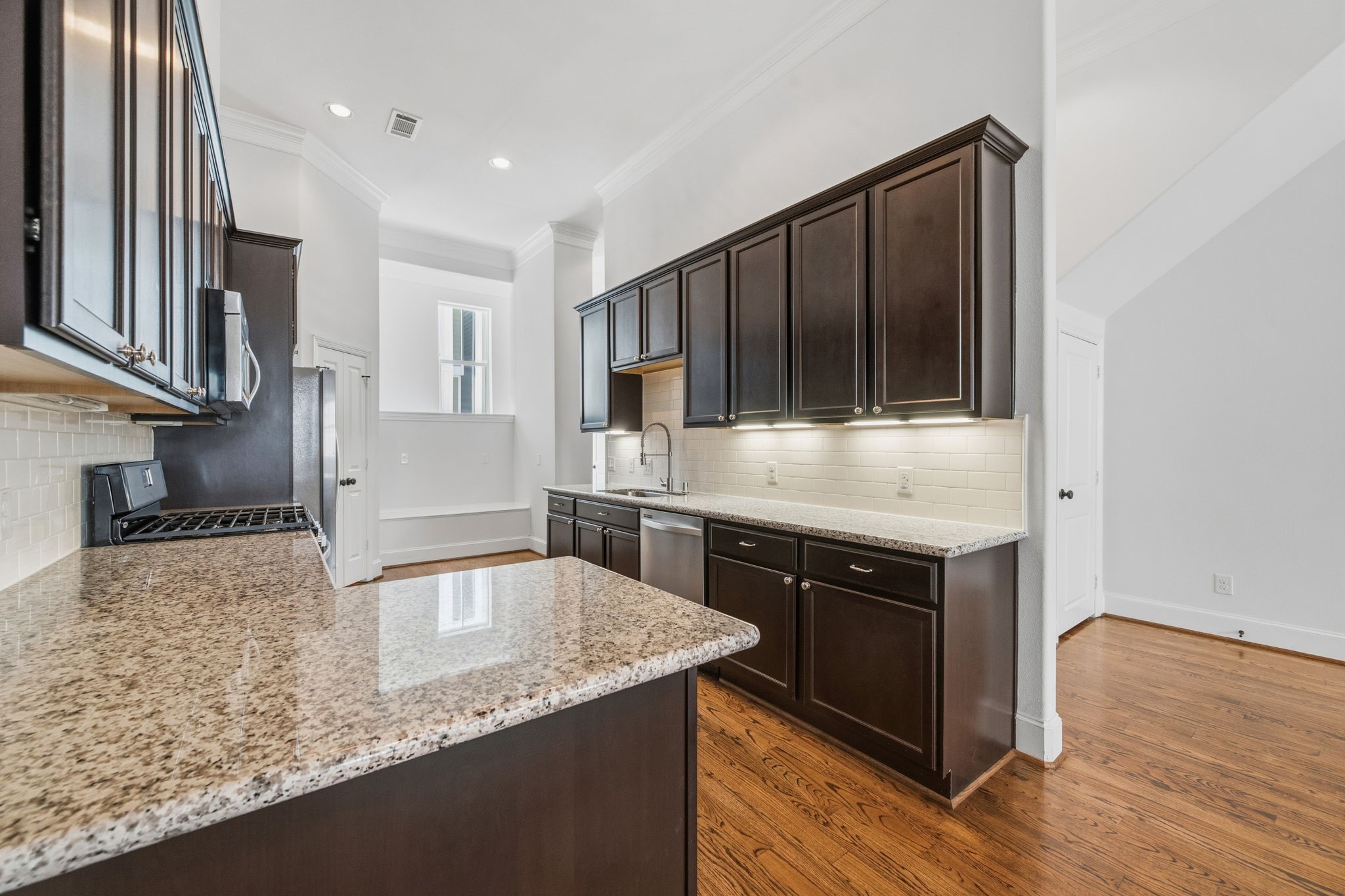 617 West 24th Street Houston, TX 77008 - Photo 13 of 28 a kitchen with granite countertop a sink a stove and cabinets