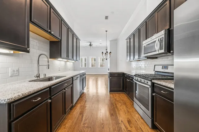 a kitchen with stainless steel appliances granite countertop lots of counter space a sink and a stove