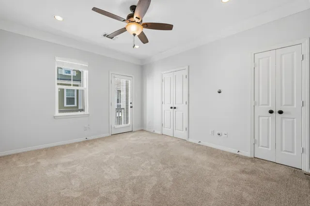 an empty room with windows and fan