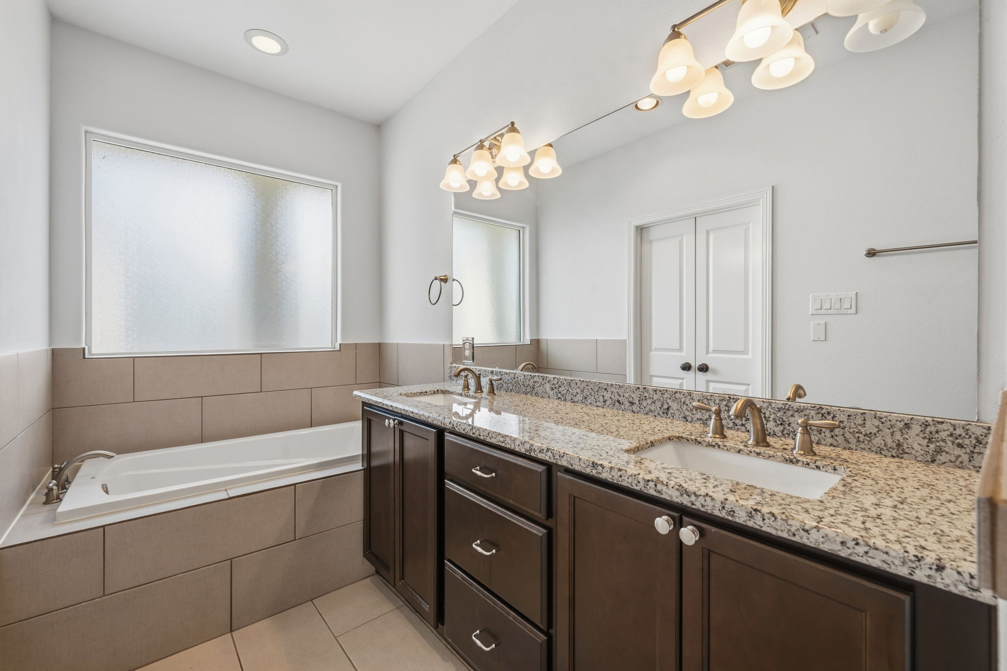 617 West 24th Street Houston, TX 77008 - Photo 20 of 28 a bathroom with a granite countertop sink a large mirror and a bathtub