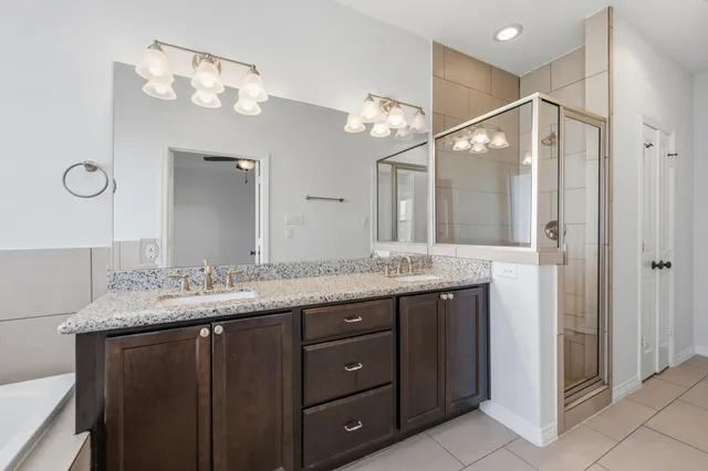 a bathroom with a granite countertop sink a mirror and a shower