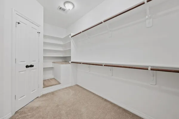 a view of walk in closet with empty racks