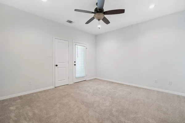 an empty room with a ceiling fan and a window