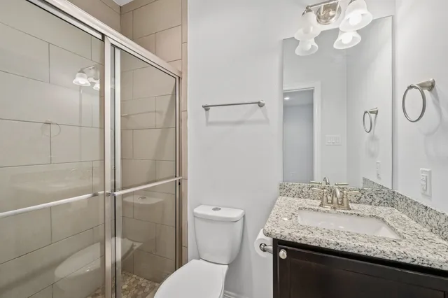 a bathroom with a granite countertop sink toilet and shower