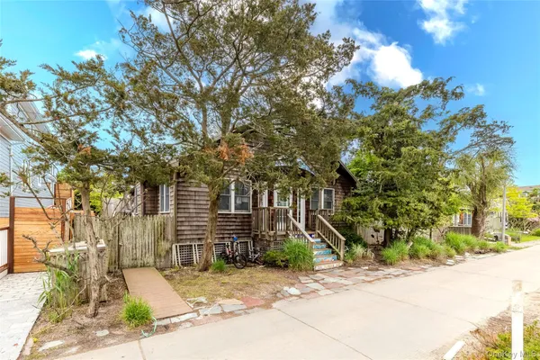 a front view of a house with a yard and tree s