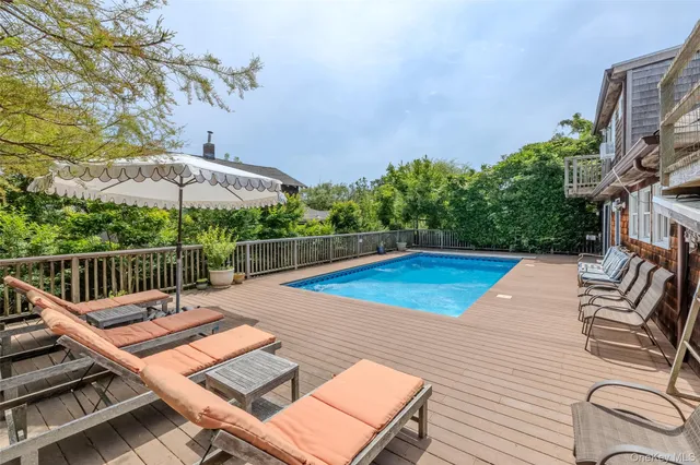 a view of a roof deck with couches wooden floor and fence