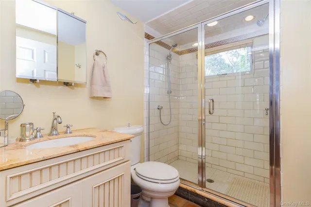 a bathroom with a granite countertop sink toilet and shower