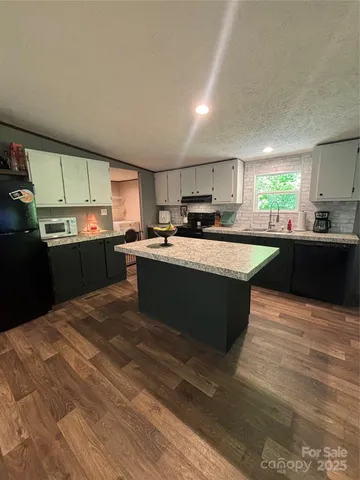 a kitchen with stainless steel appliances granite countertop a sink counter space cabinets and a window