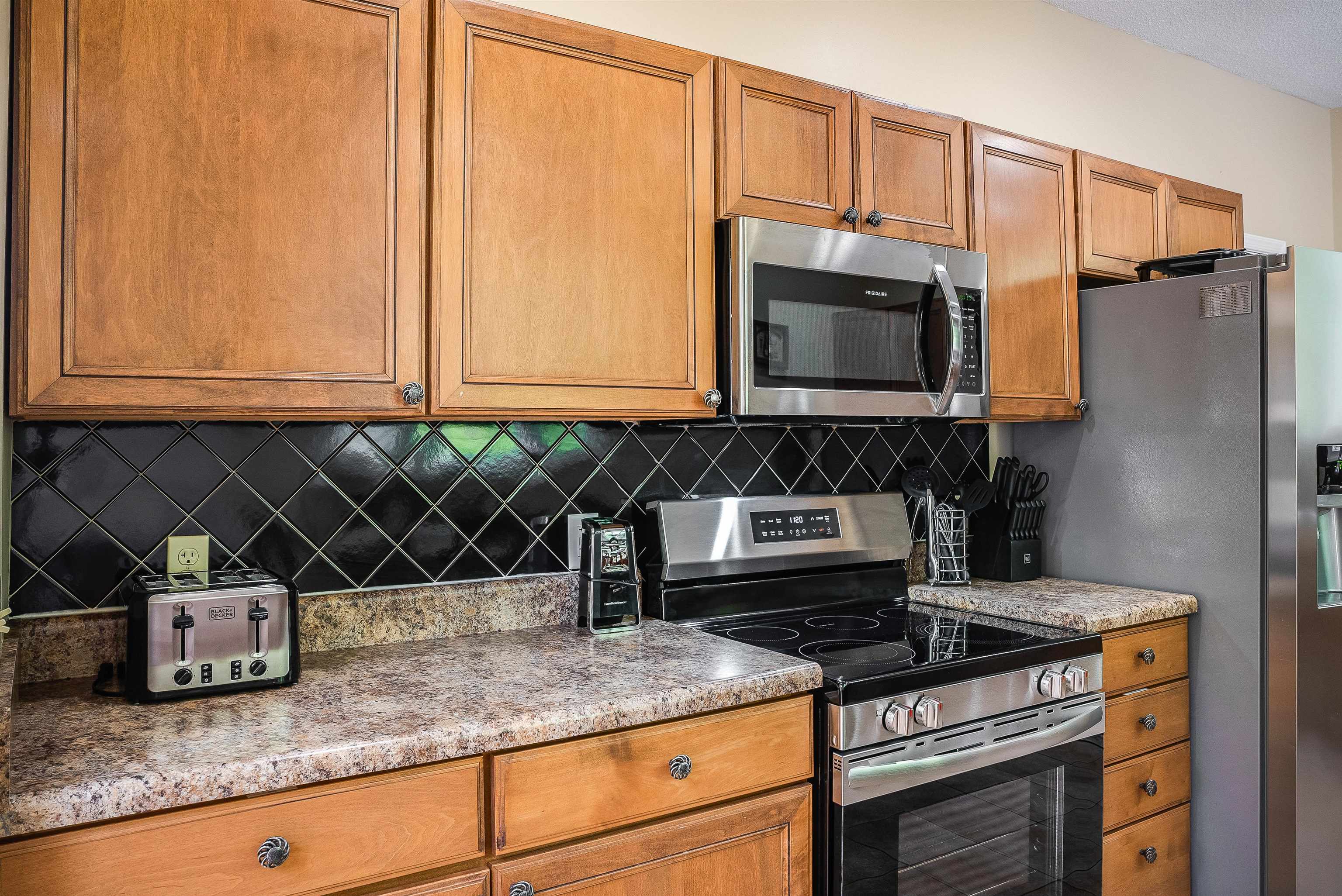 312 Rainier Road McGaheysville, VA 22840 - Photo 22 of 55 a kitchen with granite countertop a stove a microwave a sink and cabinets