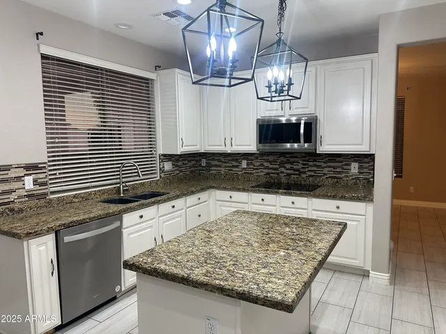 a kitchen with stainless steel appliances granite countertop a refrigerator and a stove