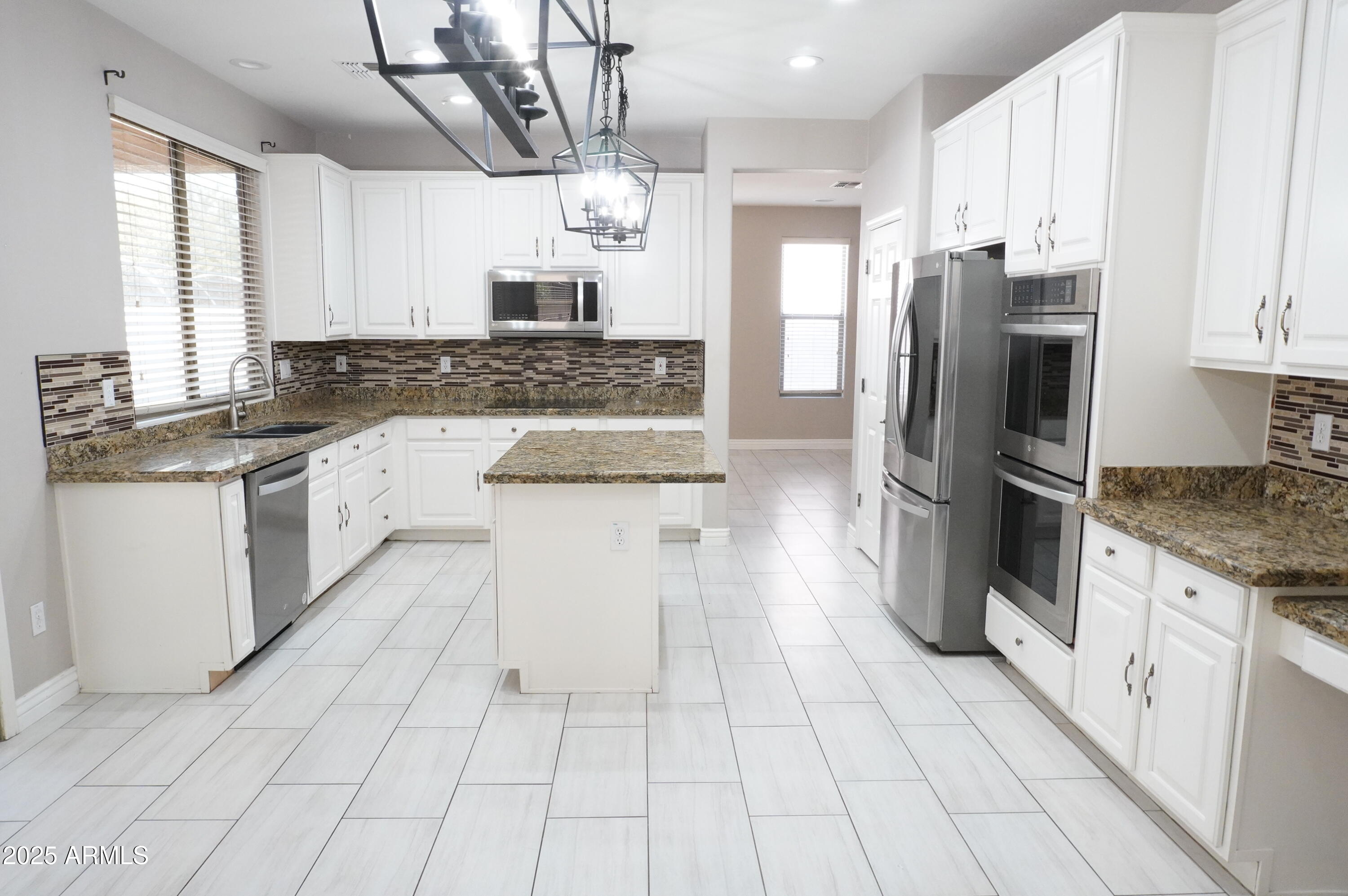 6700 South Agate Way Chandler, AZ 85249 - Photo 4 of 32 a kitchen with stainless steel appliances granite countertop a sink a stove a refrigerator and cabinets
