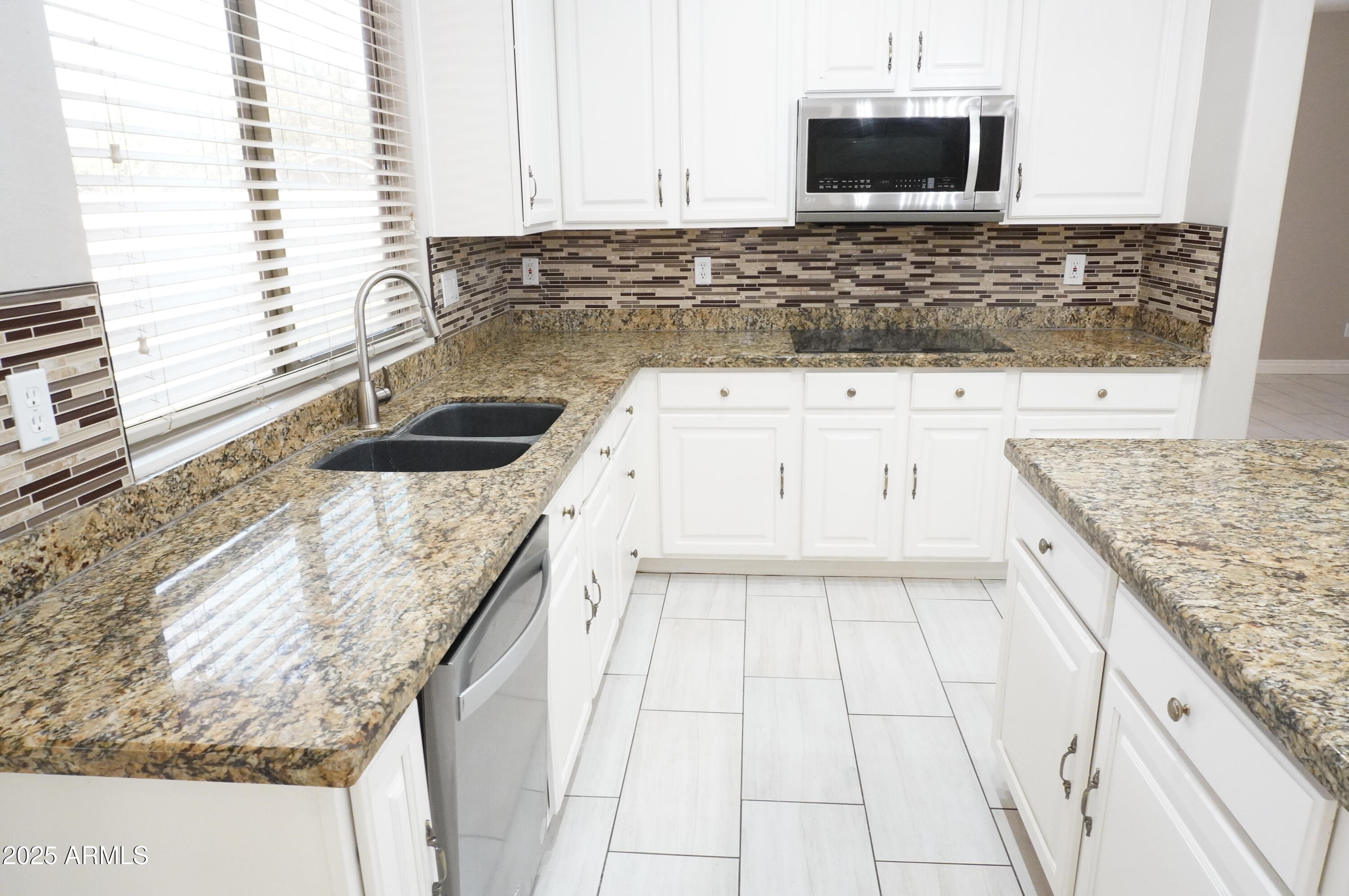 6700 South Agate Way Chandler, AZ 85249 - Photo 6 of 32 a kitchen with granite countertop a sink and a stove top oven
