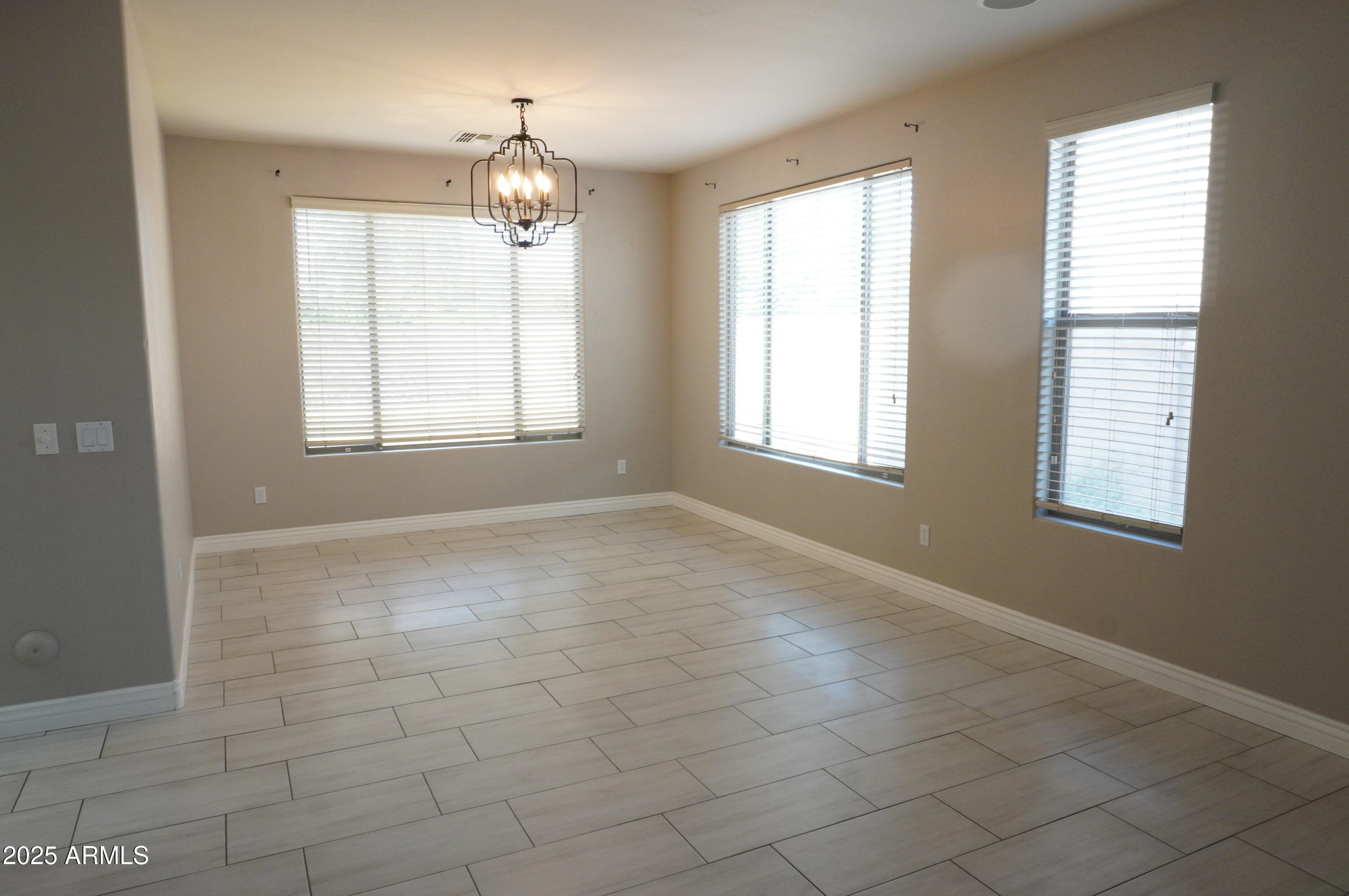 6700 South Agate Way Chandler, AZ 85249 - Photo 8 of 32 an empty room with windows and chandelier