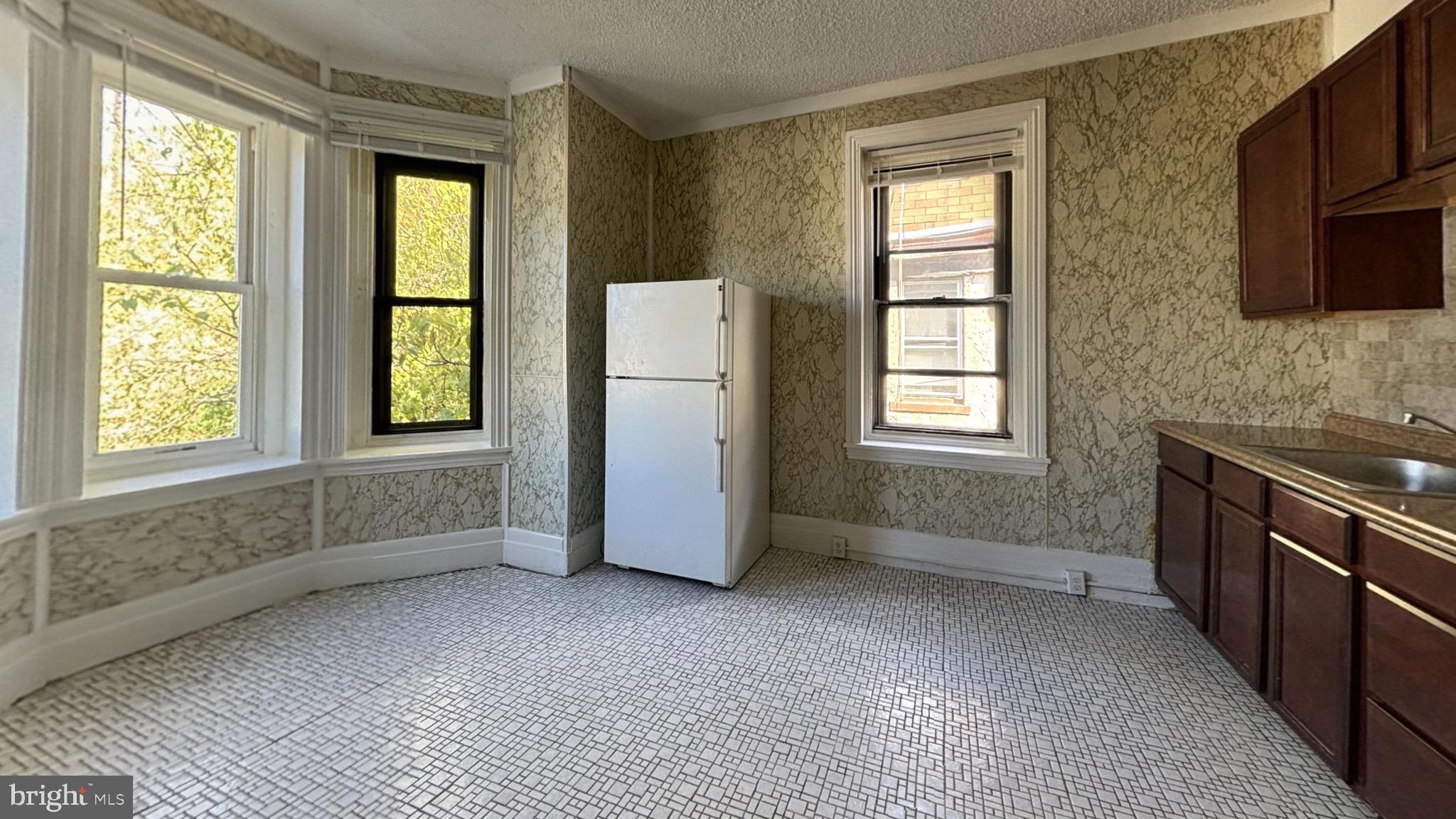 a view of a kitchen with a sink dishwasher and a refrigerator
