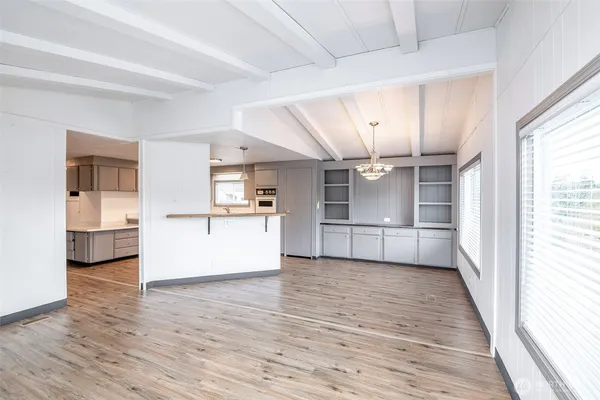 a kitchen with stainless steel appliances kitchen island granite countertop a sink cabinets and wooden floor