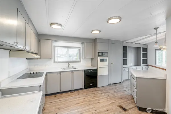 a kitchen with a sink dishwasher a stove and a refrigerator with wooden floor